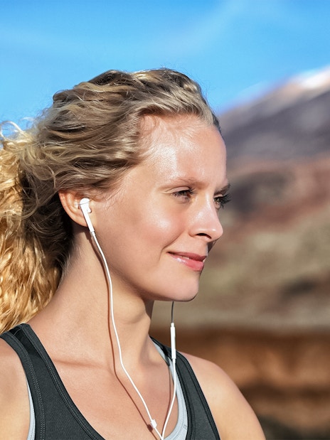 Person with earphones enjoying Mount Vesuvius view in Naples.