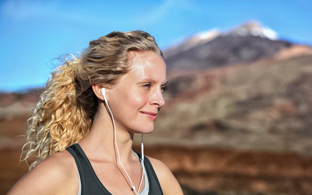 Person with earphones enjoying Mount Vesuvius view in Naples.