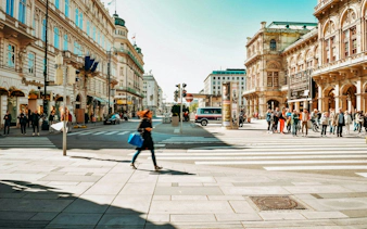 Vienna city street with pedestrians and historic architecture, part of a self-guided exploration game.