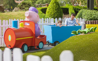 Child and adult on a colorful train ride at Heide Park.