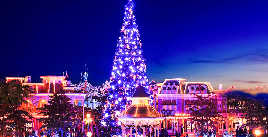 Disneyland Christmas 2025 celebration with illuminated tree and festive decorations.