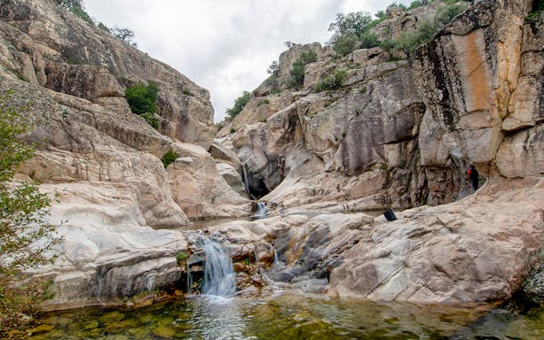 Rocky landscape with small waterfall at Cala Mariolu, Sardinia.