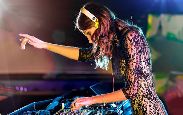 DJ performing on Evening Panorama Cruise with vibrant lights.