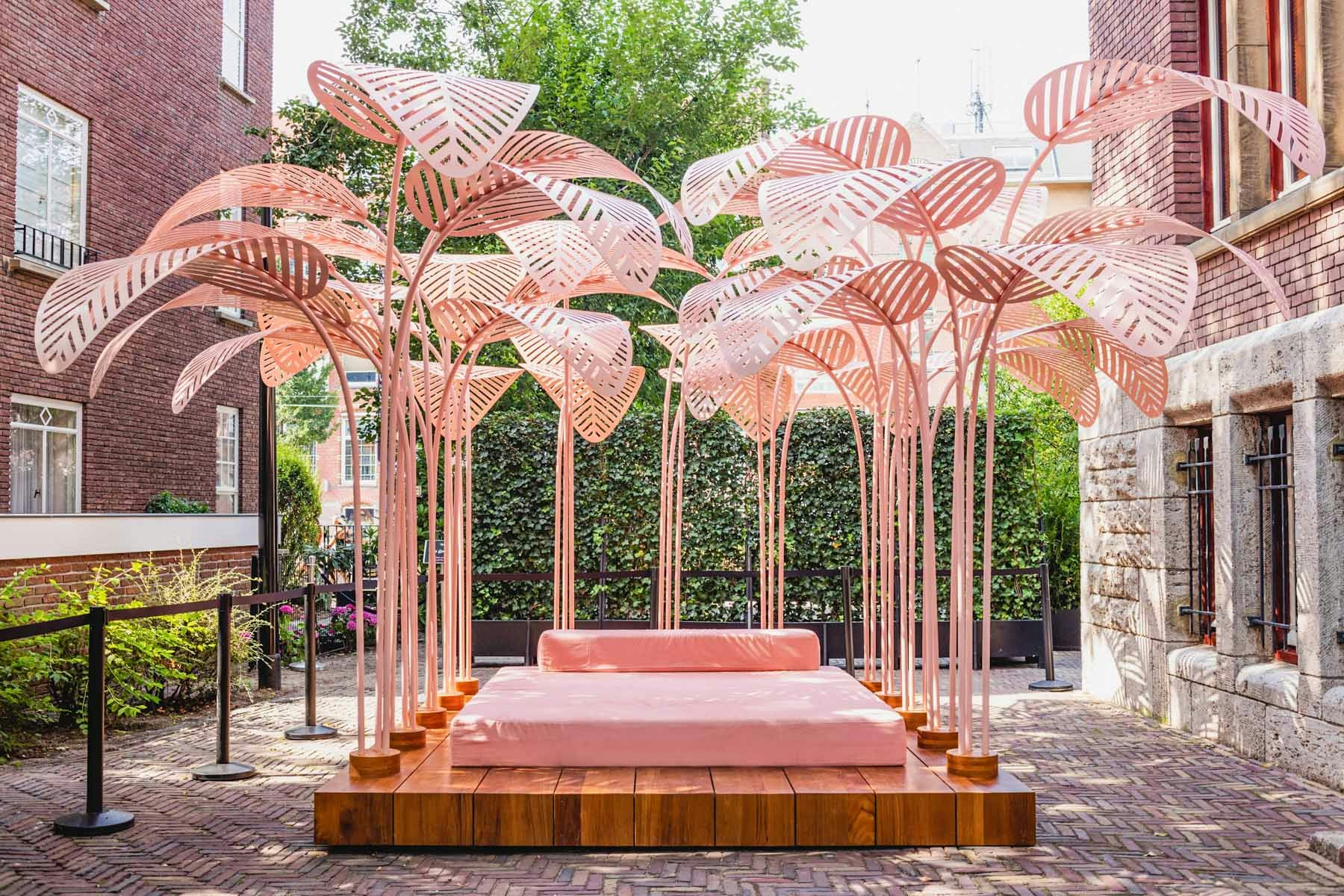 Pink metal palm sculpture installation at Moco Museum courtyard, Amsterdam.