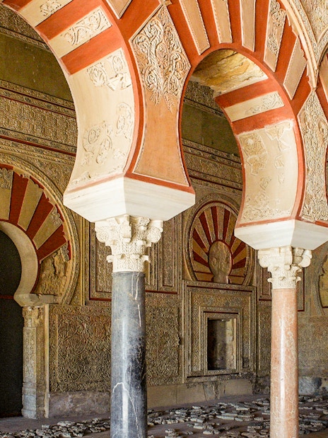 Arched pillars and intricate carvings at Medina Azahara archaeological site in Córdoba, Spain.