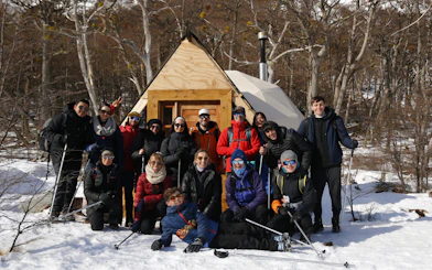 Group of trekkers posing in front of a cabin during Ojo del Albino Glacier Trekking.