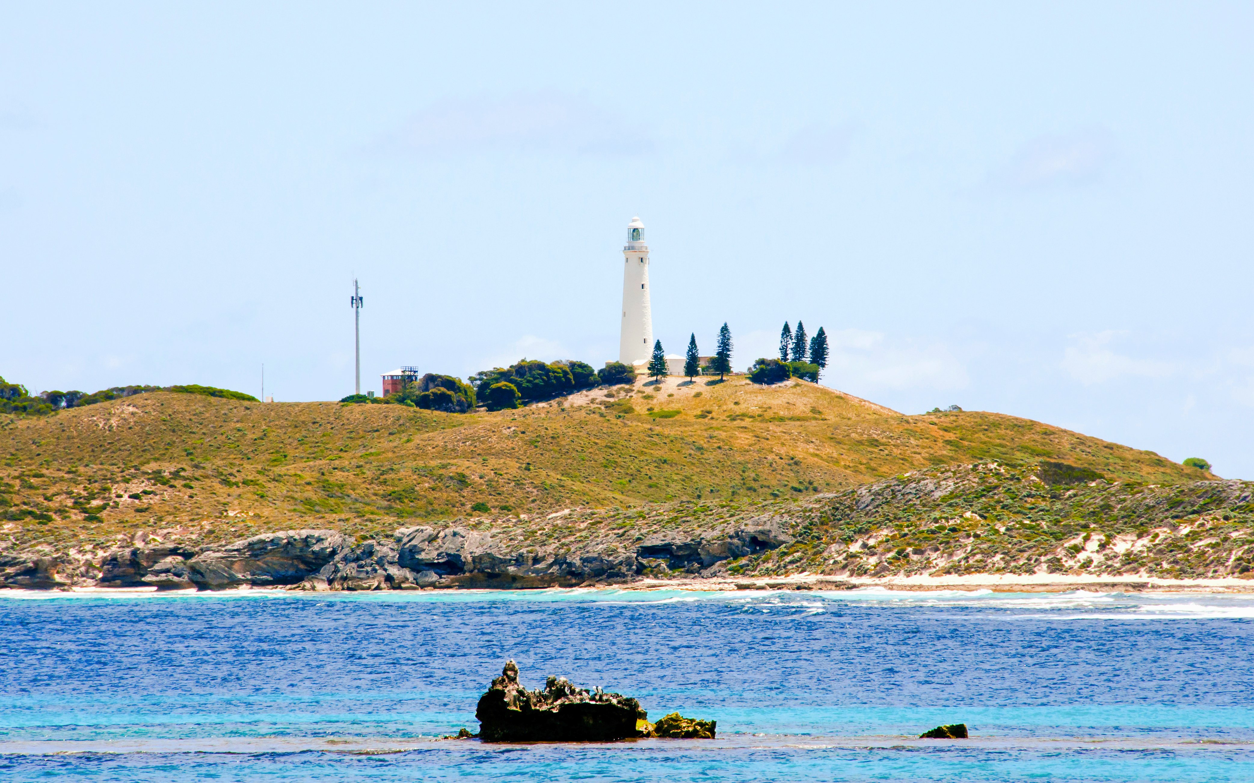 Wadjemup Lighthouse on Rottnest Island with surrounding landscape and ocean.