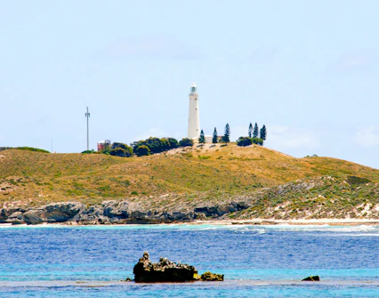 Wadjemup Lighthouse on Rottnest Island with surrounding landscape and ocean.
