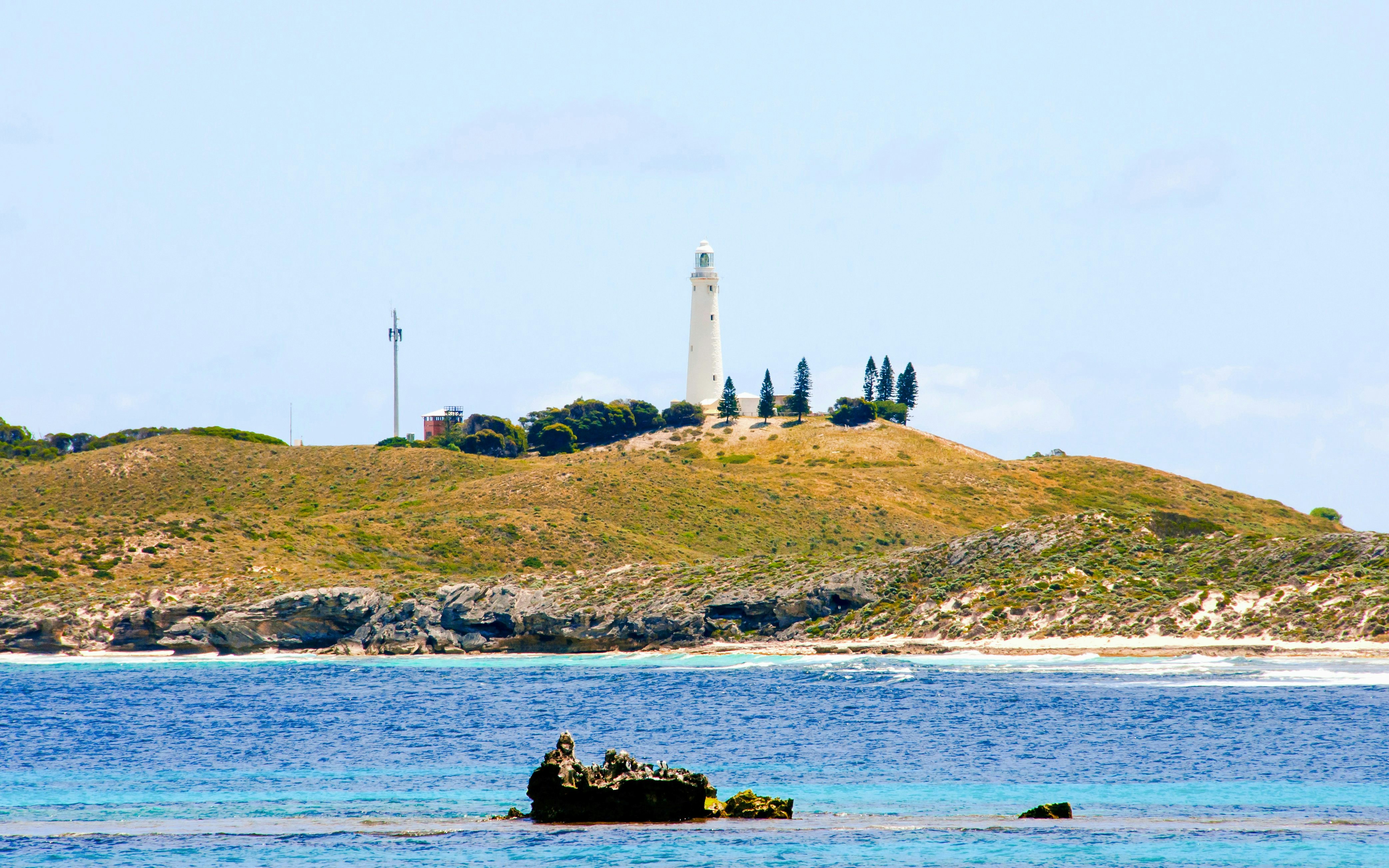 Wadjemup Lighthouse on Rottnest Island with surrounding landscape and ocean.