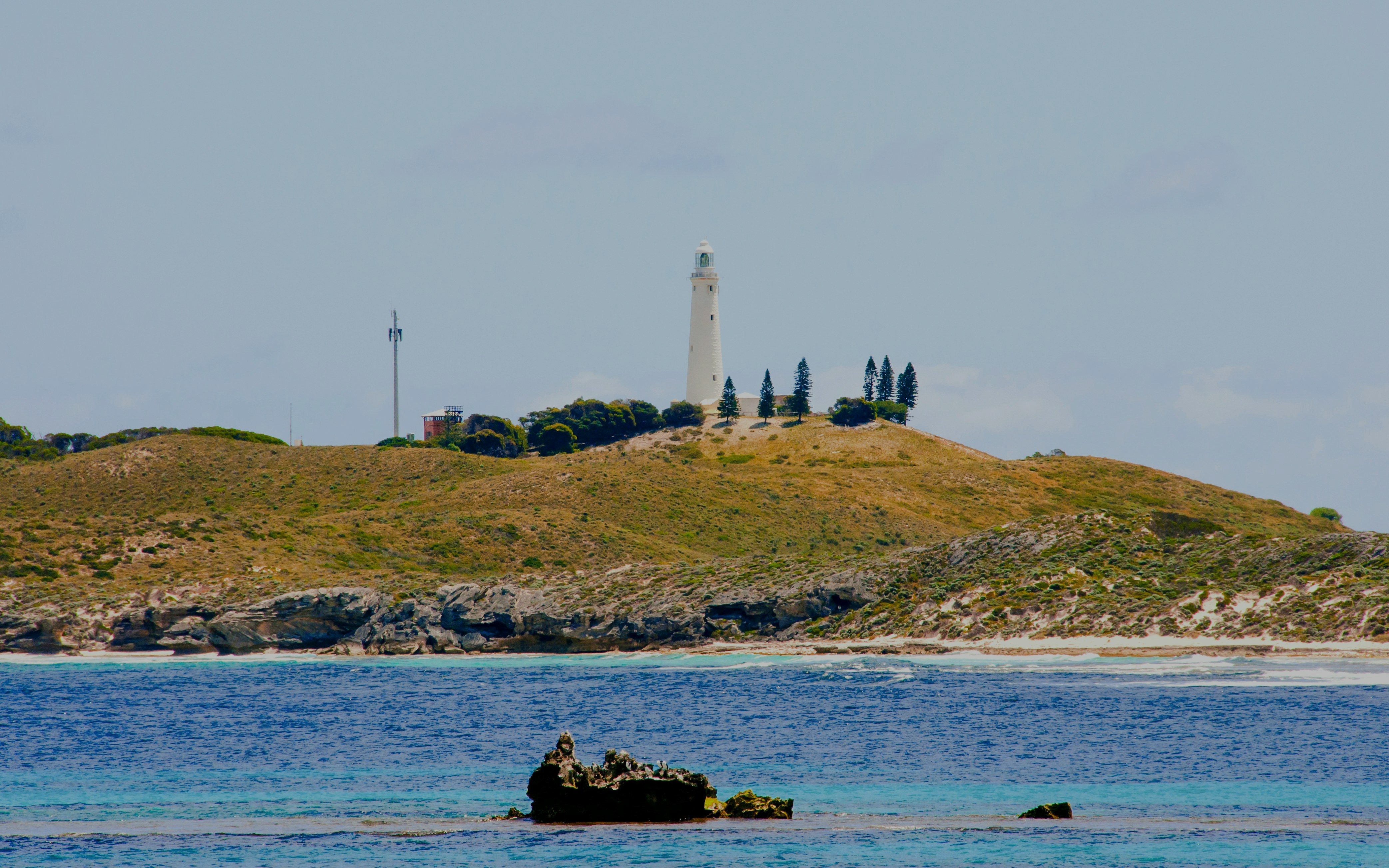 Wadjemup Lighthouse on Rottnest Island with surrounding landscape and ocean.