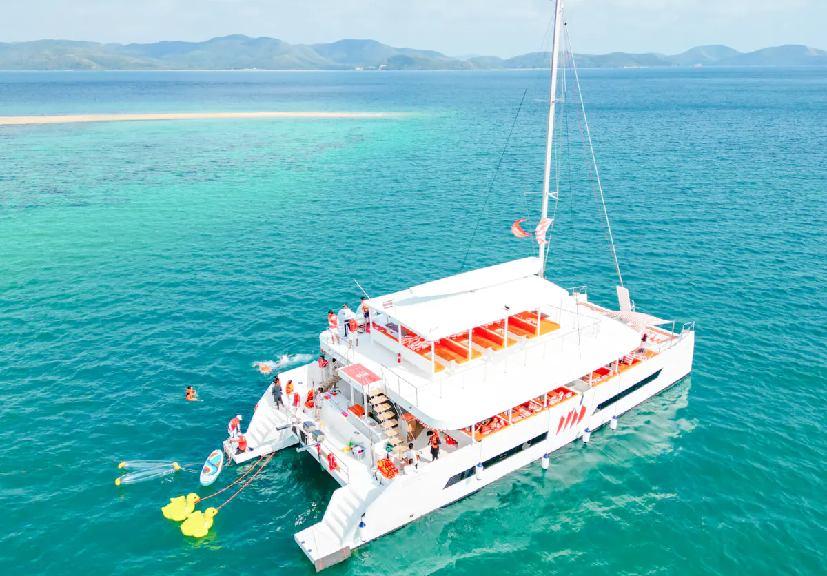 Luxury yacht with guests enjoying island hopping near Pattaya.