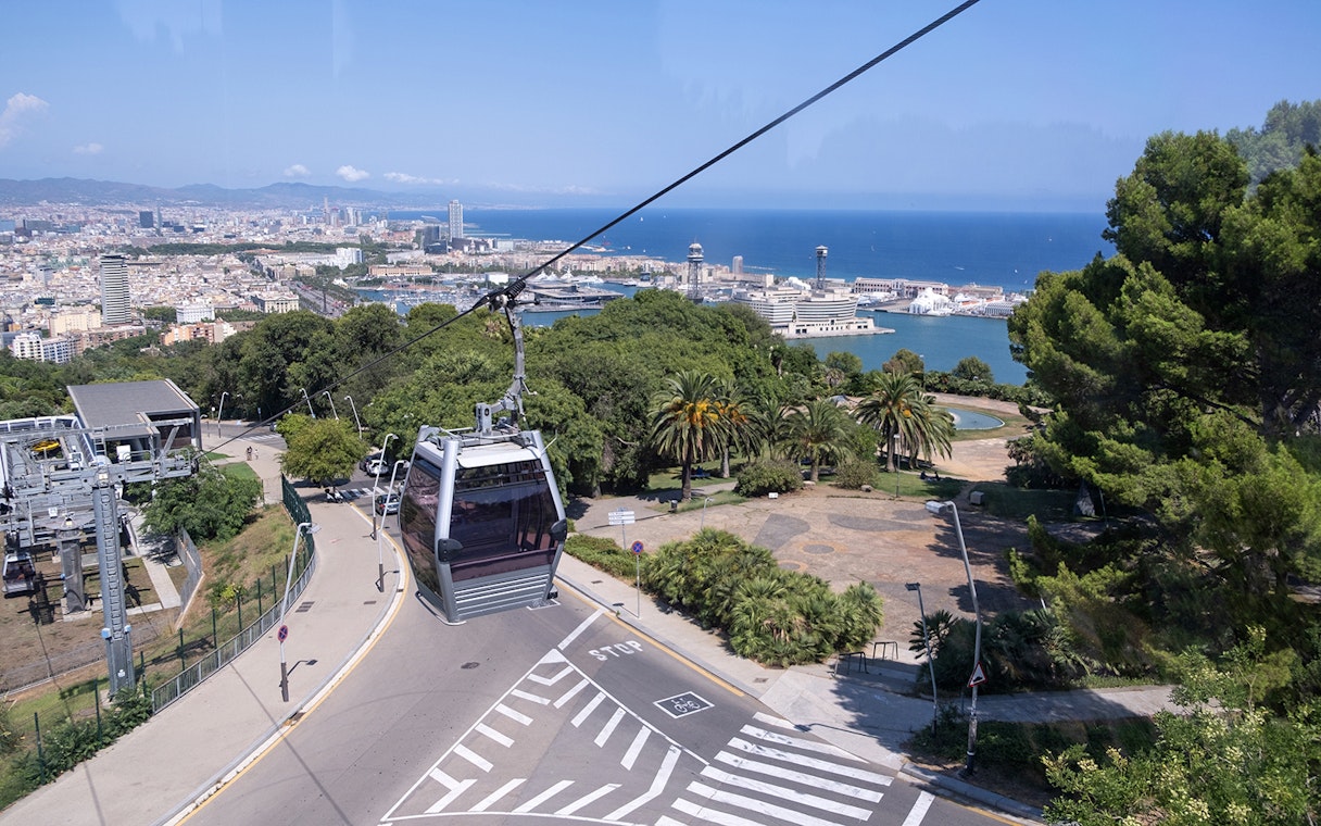 Cable car ascending Montjuic Hill with view of Sagrada Familia in background, Barcelona.