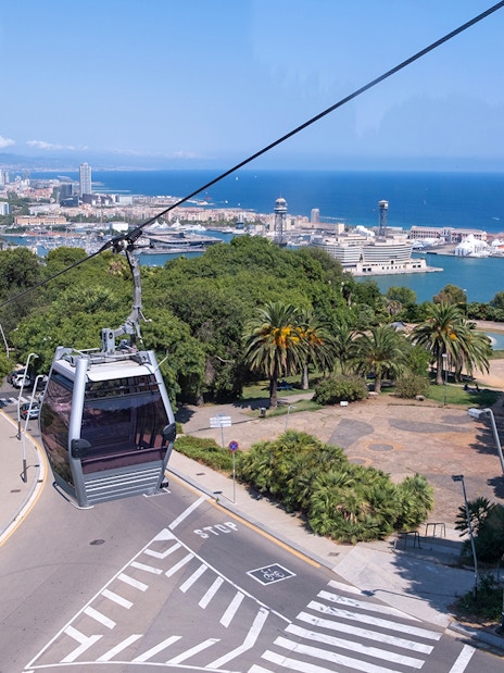 Cable car ascending Montjuic Hill with view of Sagrada Familia in background, Barcelona.