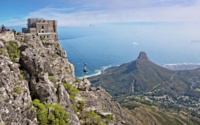 Cable car ascending Table Mountain with view of Lion's Head and Cape Town, South Africa.