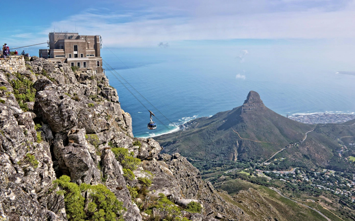 Cable car ascending Table Mountain with view of Lion's Head and Cape Town, South Africa.