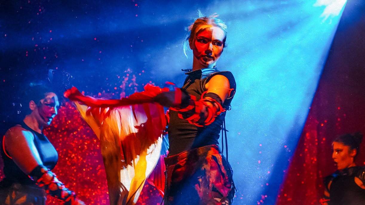 Performers in Halloween costumes at Thorpe Park show with dramatic lighting.