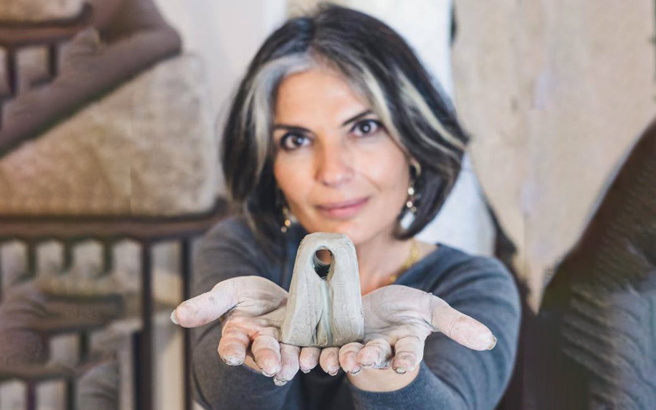 Person holding a clay sculpture during an ancient craft workshop in Ortigia.