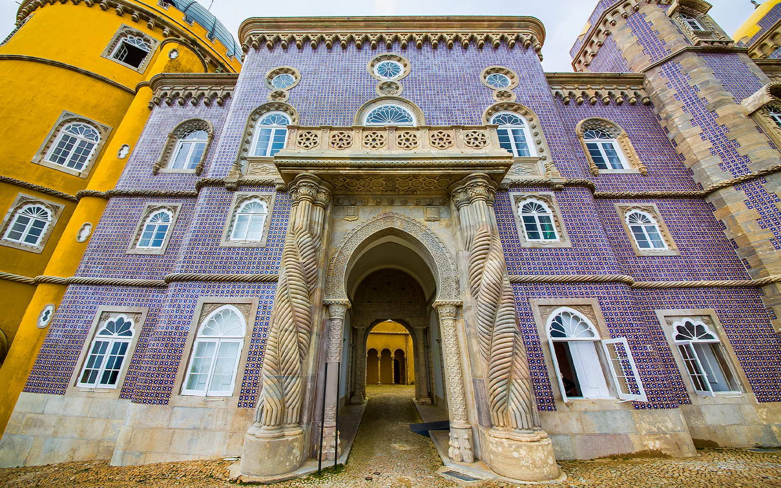 Pena Palace entrance with ornate columns and colorful facade in Sintra, Portugal.