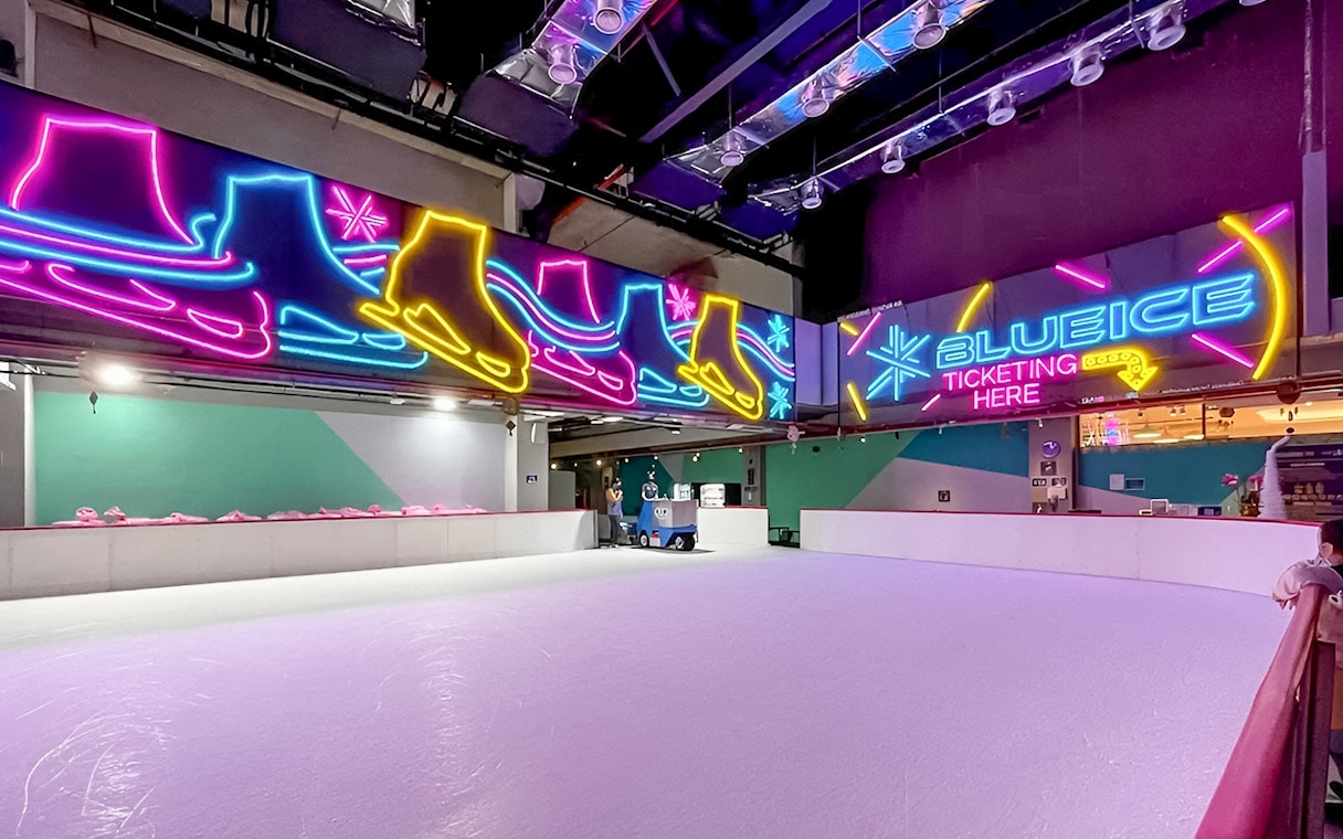 Indoor ice skating rink with neon skate signs at Blue Ice Snow Park, 163 Retail Park.