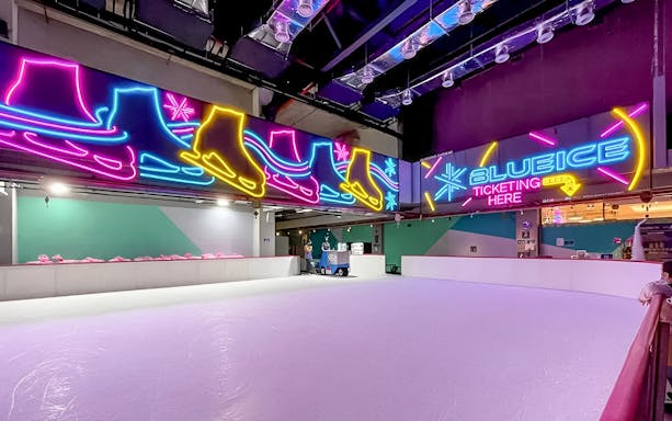 Indoor ice skating rink with neon skate signs at Blue Ice Snow Park, 163 Retail Park.