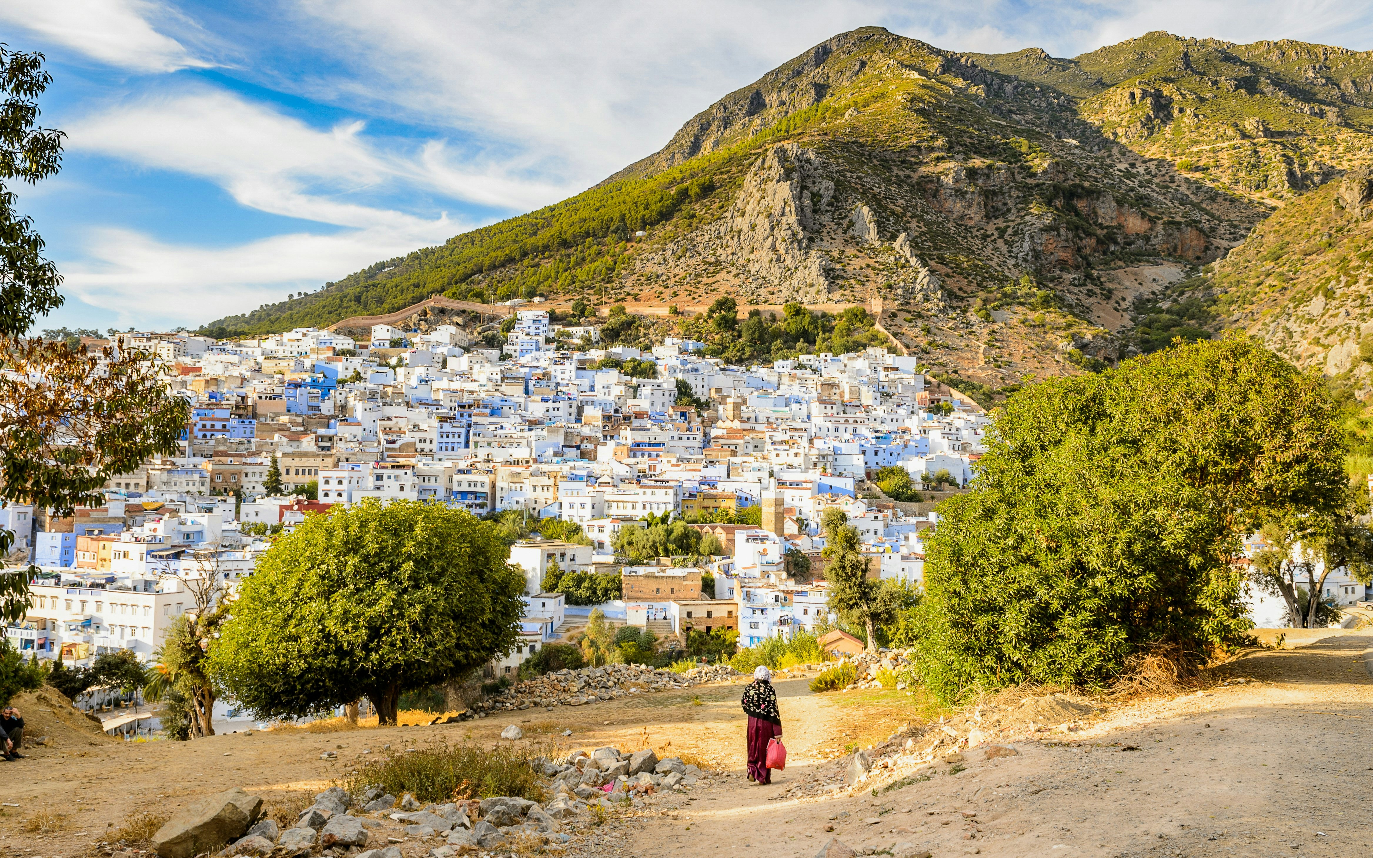 Panorama of Chefchaouen's blue buildings with Rif Mountains in Morocco.