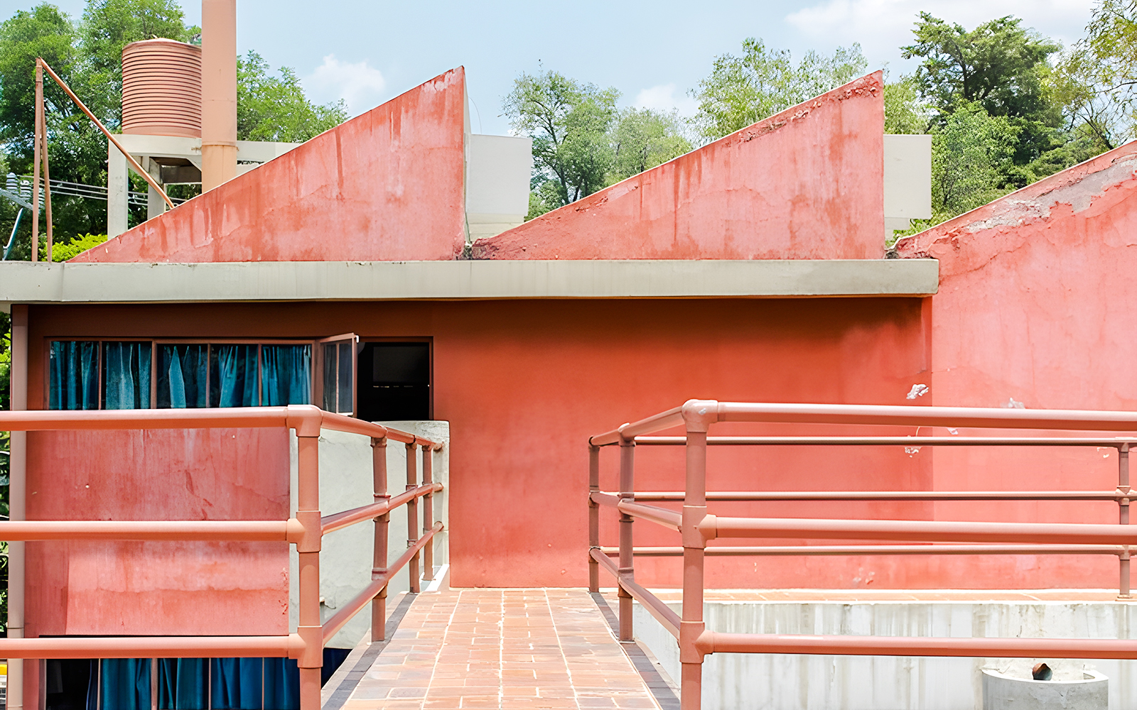 Red facade and walkway at Museo Casa Estudio Diego Rivera y Frida Kahlo, Mexico City.