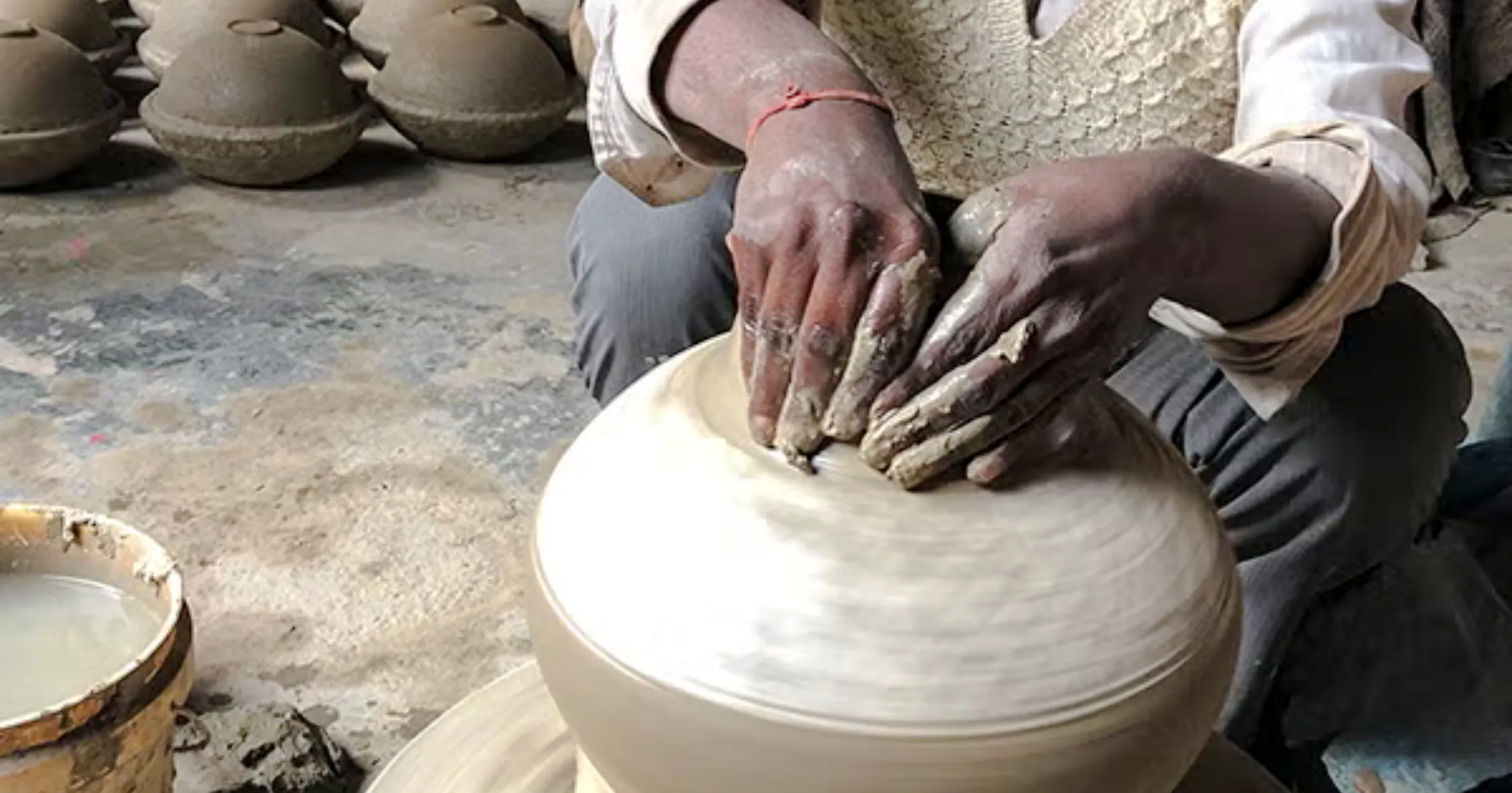 Potter shaping clay on a wheel at a traditional workshop in Al Haouz, Marrakesh.