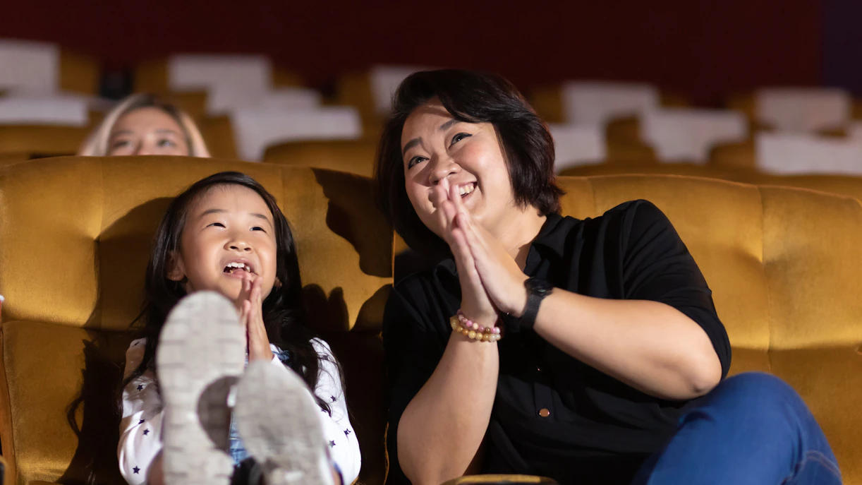 Family enjoying a movie in a cinema theater.