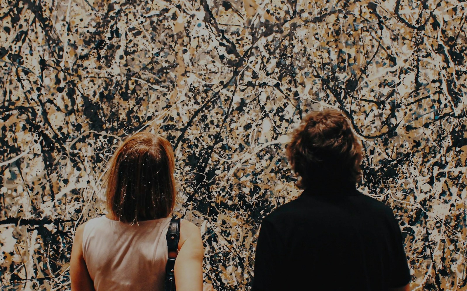 Two people are viewing Jackson Pollock's painting, One: Number 31, 1950