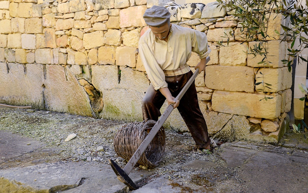 Worker demonstrating traditional stone cutting at Limestone Heritage, Malta.