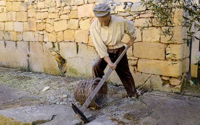 Worker demonstrating traditional stone cutting at Limestone Heritage, Malta.