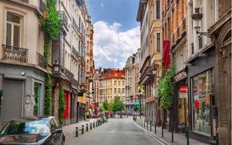 Brussels city street with historic buildings, part of the self-guided exploration game.