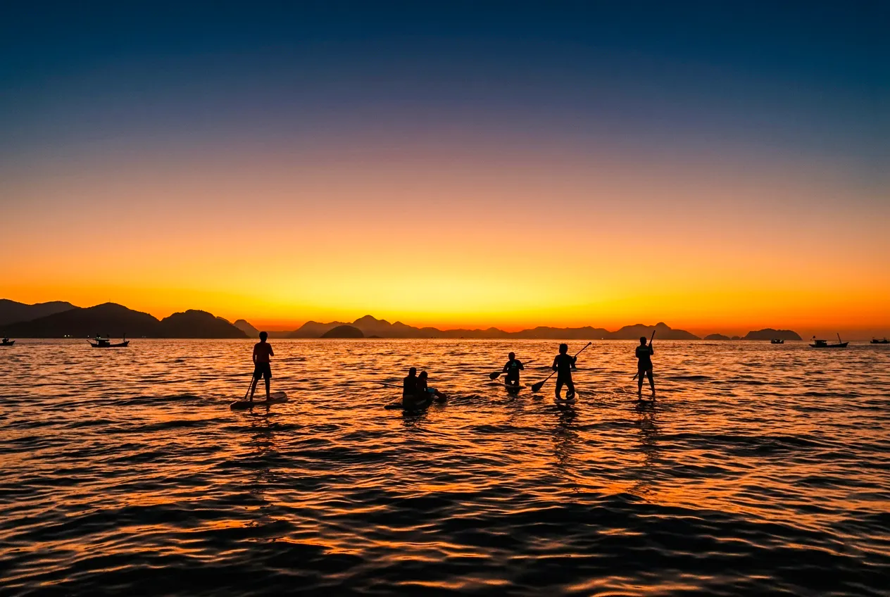 Stand-up paddleboarders at sunrise in Rio de Janeiro.