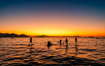 Stand-up paddleboarders at sunrise in Rio de Janeiro.