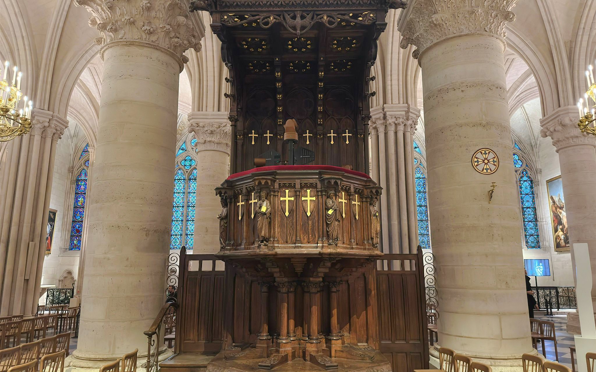 Pulpit with ornate carvings and stained glass windows inside Notre Dame Cathedral, Paris.