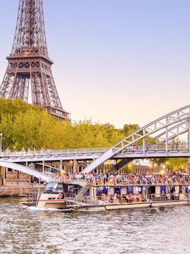 Seine River cruise boat near Eiffel Tower and bridge in Paris.