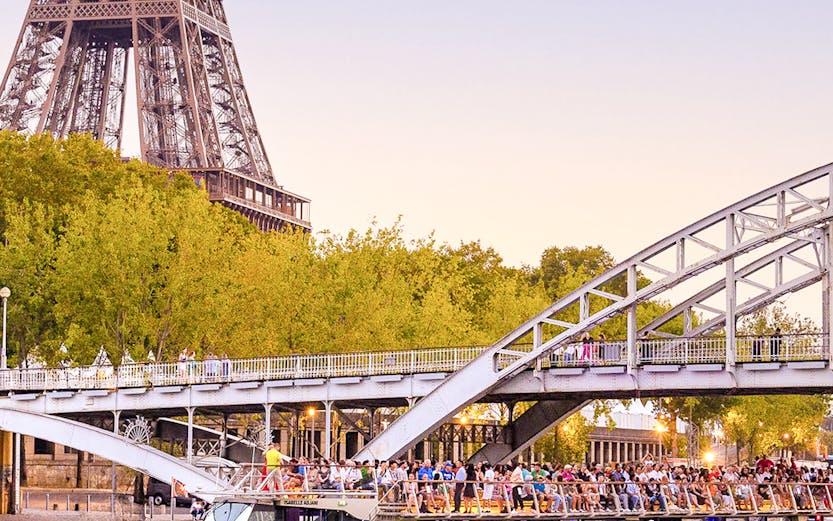 Seine River cruise boat near Eiffel Tower and bridge in Paris.