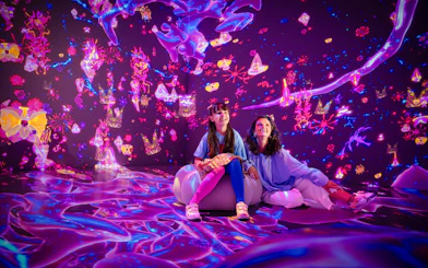 Interactive digital art display at House Of Hype with two people enjoying vibrant projections.