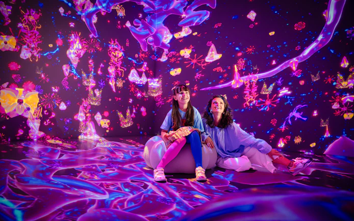 Interactive digital art display at House Of Hype with two people enjoying vibrant projections.
