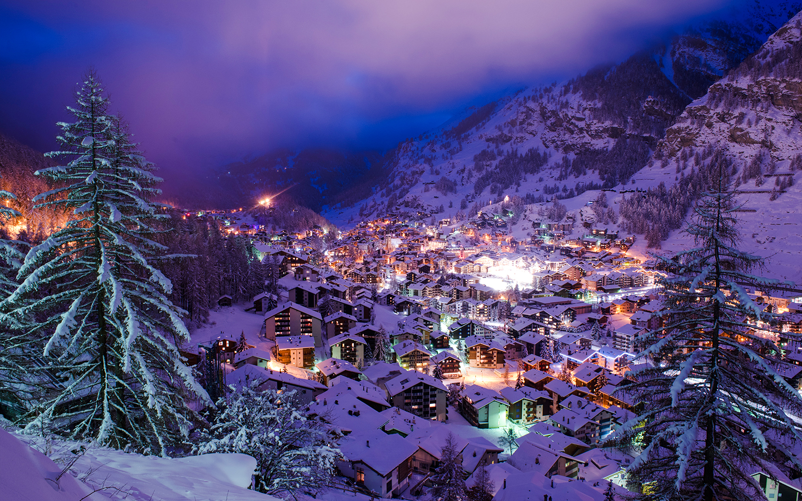Aerial view of Zermatt Valley illuminated during Christmas, surrounded by snowy mountains.