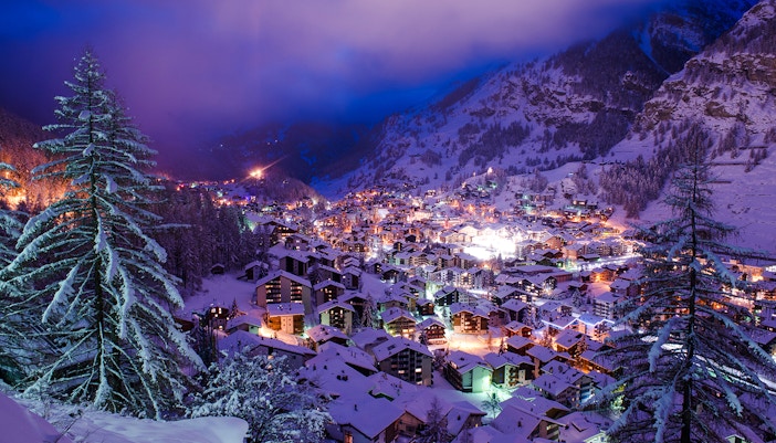 Aerial view of Zermatt Valley illuminated during Christmas, surrounded by snowy mountains.