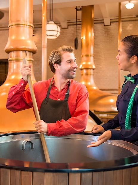 Guests with guide at brewing vat in Heineken Experience, Amsterdam.