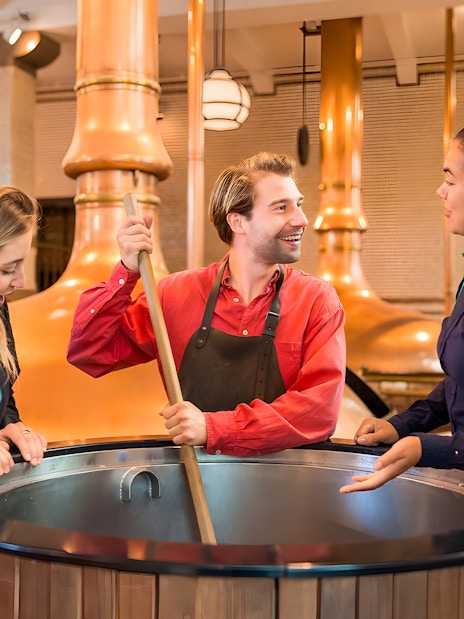 Guests with guide at brewing vat in Heineken Experience, Amsterdam.
