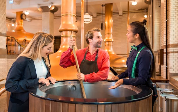 Guests with guide at brewing vat in Heineken Experience, Amsterdam.
