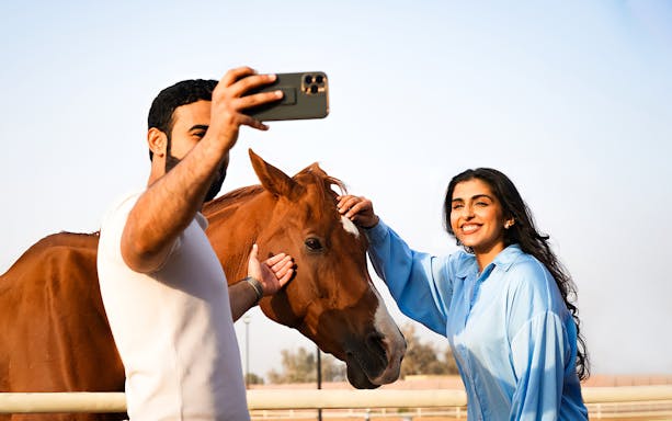 Visitors taking a selfie with a horse at Mleiha Arena Ride.