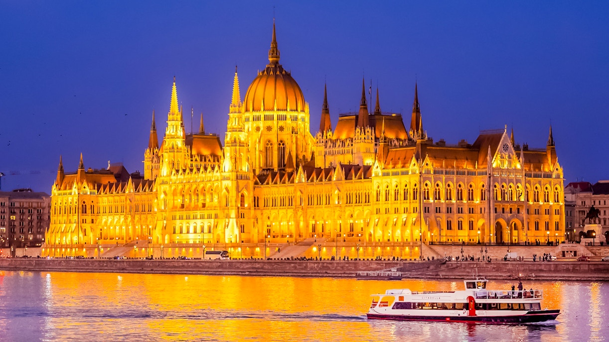 Budapest Danube River nighttime cruise with illuminated cityscape and historic buildings.