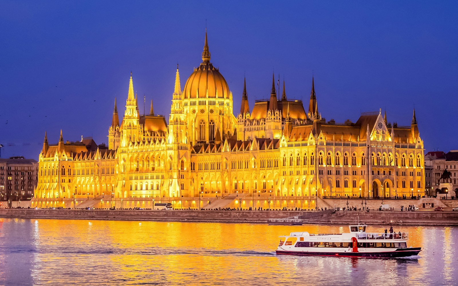 Budapest Danube River nighttime cruise with illuminated cityscape and historic buildings.