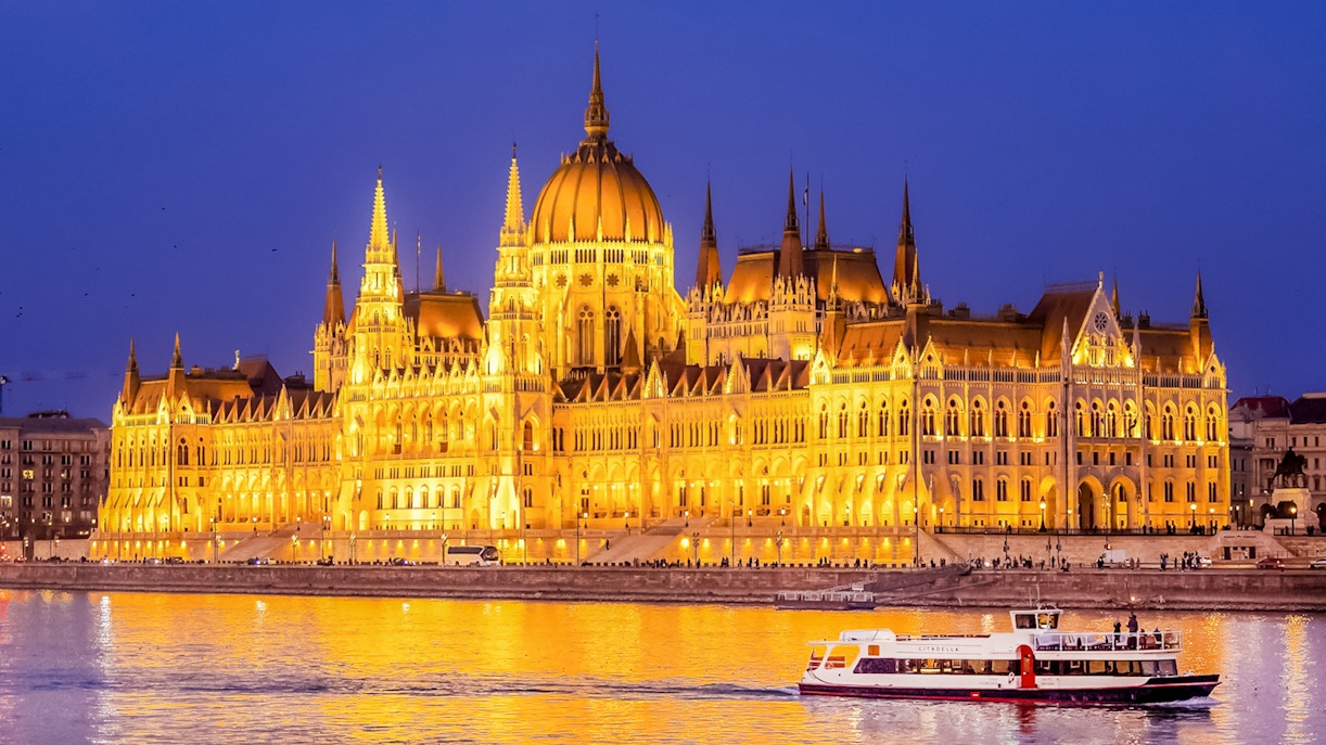 Budapest Danube River nighttime cruise with illuminated cityscape and historic buildings.