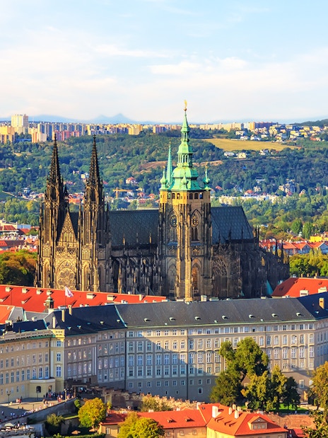 Prague Castle with St. Vitus Cathedral, view over city rooftops.