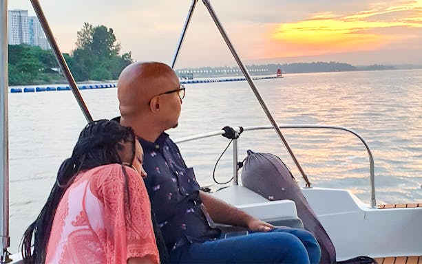 Couple enjoying sunset on a boat during Let's Go Kelong tour.